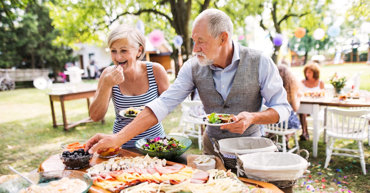 A Person Sitting At A Table With A Plate Of Food