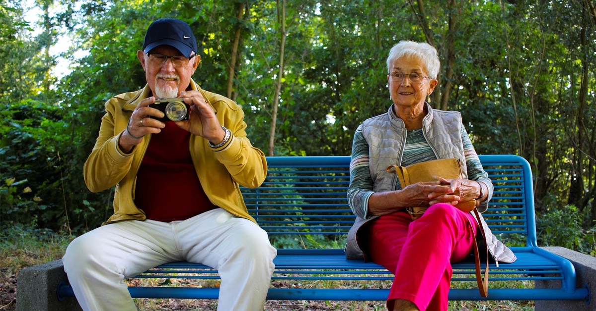 A Person Sitting On A Bench Talking On A Cell Phone